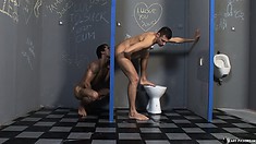 Two Fit Naked Studs Play With Each Other Through A Glory Hole